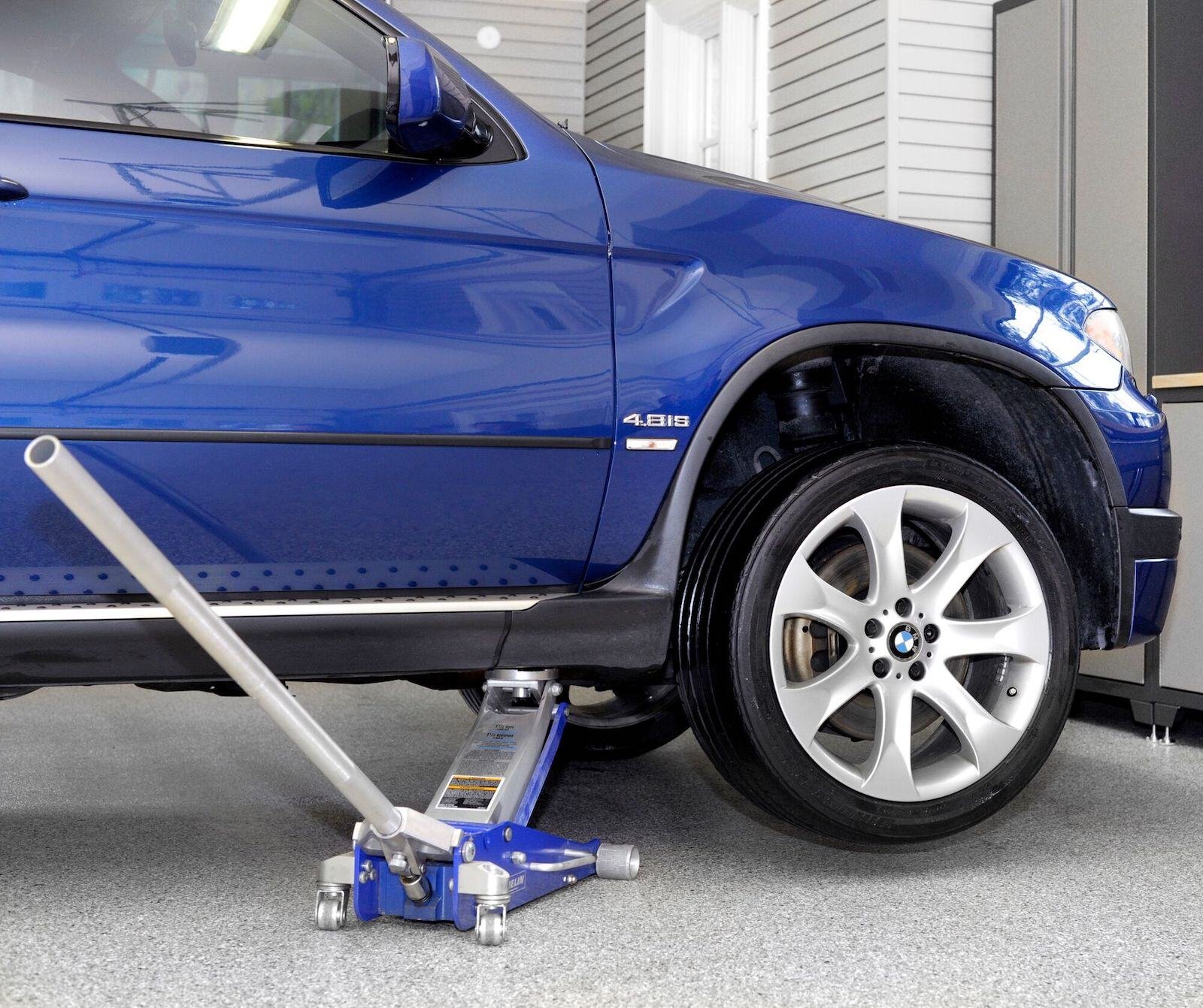 car being jacked up on coated garage floor