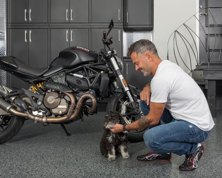 man petting dog in garage